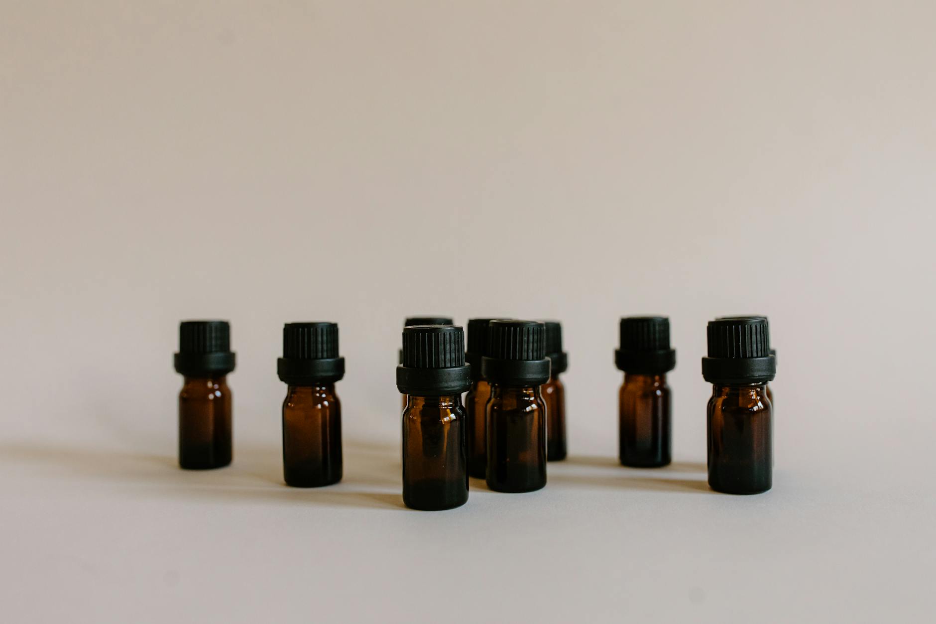 Najlepsze oleje nośnikowe do perfum: jojoba, frakcjonowany kokos, migdał Bursztynowe butelki z olejkami bazowymi do naturalnych perfum