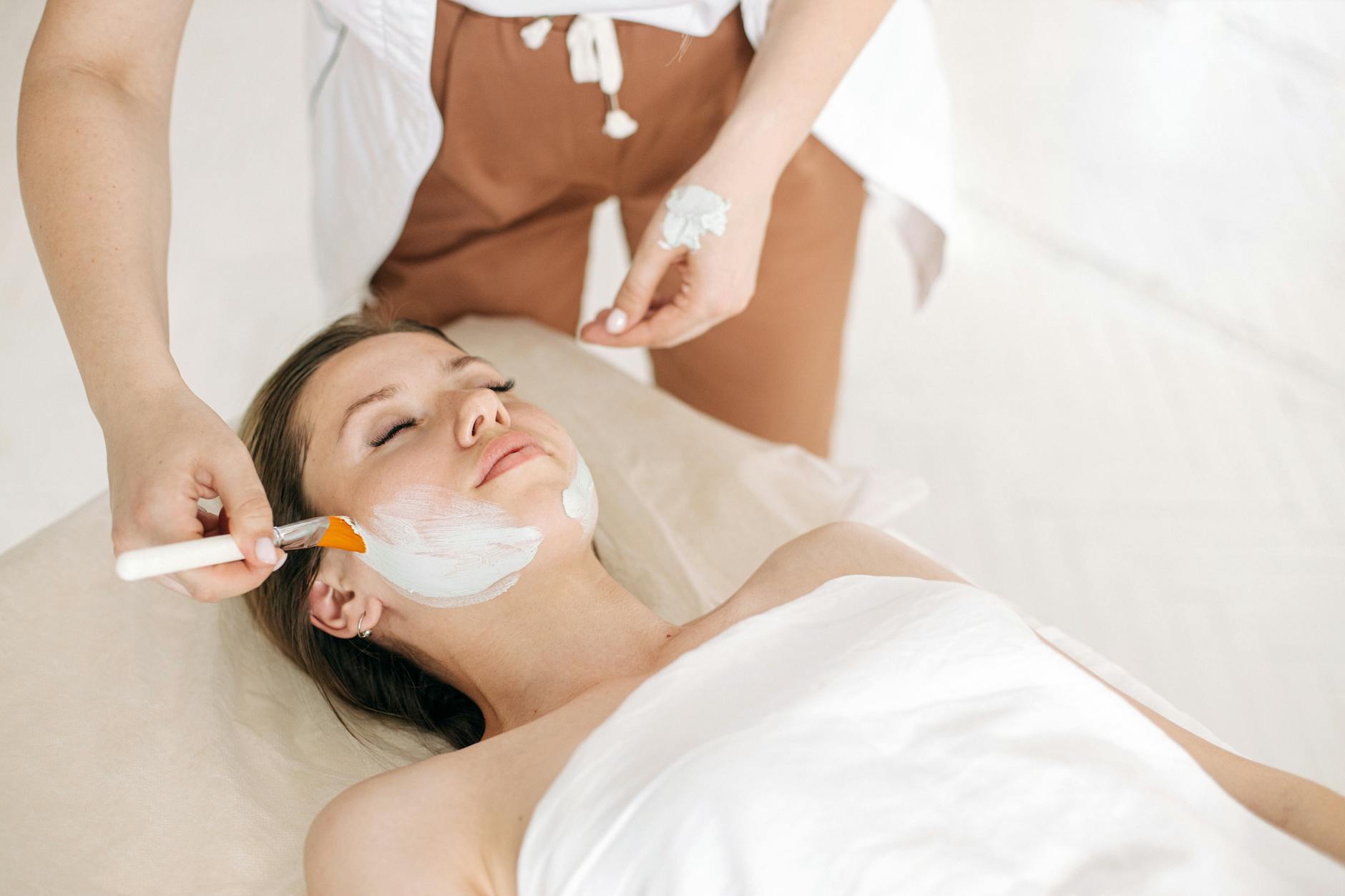 Kobieta podczas relaksacyjnego zabiegu na twarz w spa