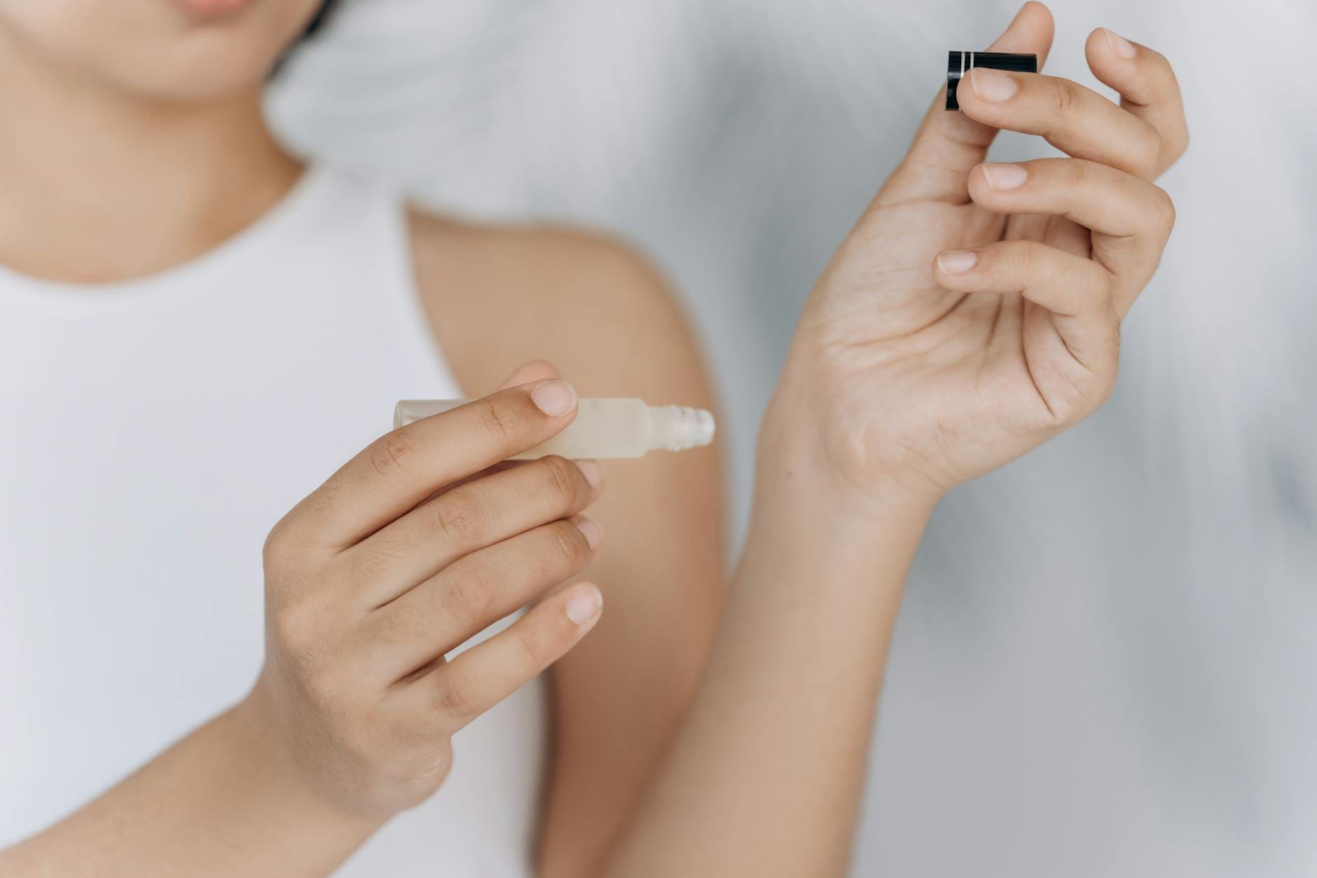 Kobieta o kręconych włosach nakłada serum pielęgnacyjne pipetą