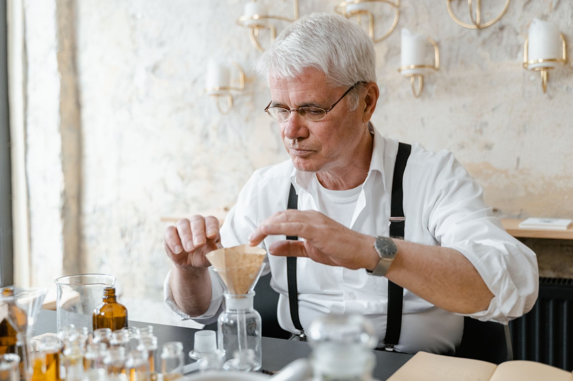 Perfumiarz w laboratorium przygotowuje próbkę kompozycji zapachowej Perfumiarz w laboratorium przygotowuje próbkę kompozycji zapachowej